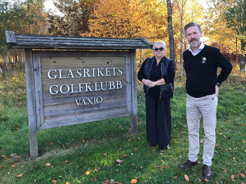 Anzie Monell och Sven Johannesson vid välkomstskylten till Glasrikets golfklubb Växjö.