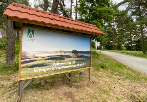 En skylt vid infarten till Åkersberga GK med texten "Välkommen till Sveriges trivsammaste golfklubb!