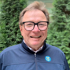 Porträttbild på man i 55-årsåldern med glasögon och blå tröja med SGF-logotyp. 