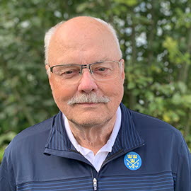 Porträttbild på man i 60-årsåldern i blå tröja med SGF-logga.