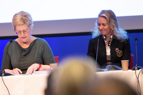 Två kvinnor sitter vid ett podium och leder ett möte.
